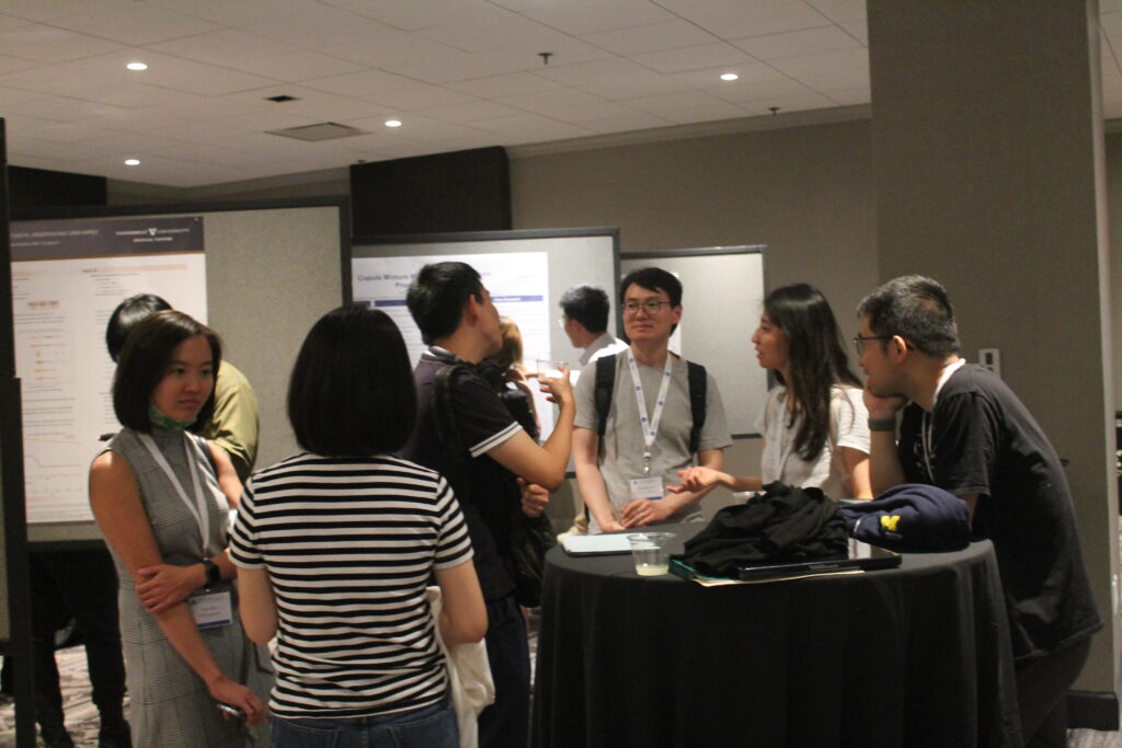 Symposium participants mingle around refreshment tables at the Monday night poster session